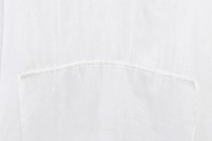 Detailed macro view of white linen cotton fabric texture and fine stitching on the shirt