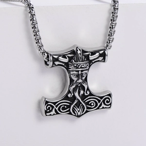 Macro detail of vintage silver Viking Mjolnir pendant with intricate Nordic carvings