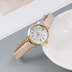Detailed close-up of a women's gold quartz watch with a textured champagne leather strap