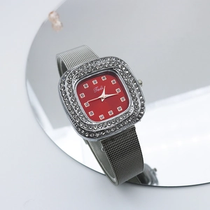 Detailed macro view of the square red dial with rhinestone bezel and mesh watch band