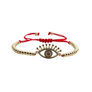 Handmade red braided cord bracelet with gold beads and a Turkish evil eye pendant