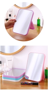 Foldable rectangular desktop makeup mirror in multiple colors on a wooden vanity table
