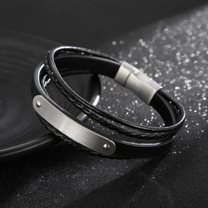 Dettaglio di bracciale multistrato in pelle intrecciata con chiusura magnetica