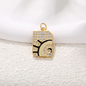 Macro shot of gold tarot rectangle pendant with zircon inlay and black enamel finish