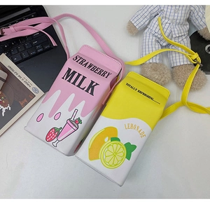 Flat lay of strawberry and lemonade milk carton crossbody bags with adjustable straps