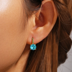 Macro view of 925 sterling silver hoop earring with blue stone and green accents