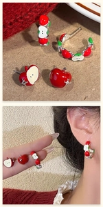 Detailed view of asymmetric red apple earrings set with enamel and rhinestone accents