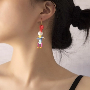 Close-up of handmade beaded character earring with faux pearls on model's ear