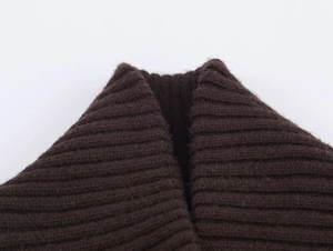 Detailed macro view of dark brown ribbed knit jacket showing neckline and fabric texture