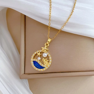 Detailed close-up of golden necklace with pearls and blue enamel stars on jewelry box