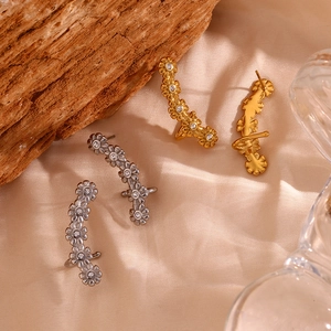 Detail view of 18K gold and silver plated flower ear cuffs with zircon stones on silk