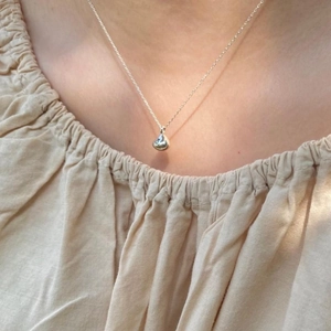Minimalist 925 sterling silver waterdrop pendant necklace shown on a female neck model