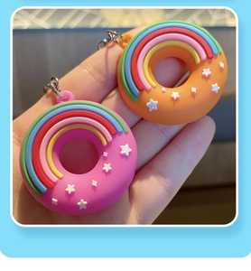 Gros plan de porte-clés beignets mignons en silicone rose et orange avec étoiles