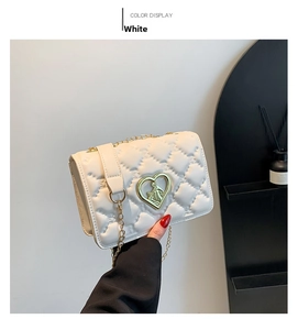 Gros plan du sac bandoulière blanc matelassé avec gaufrage et boucle en forme de cœur