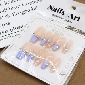 Purple French press-on nails with glitter, moon and star accents in a retail package