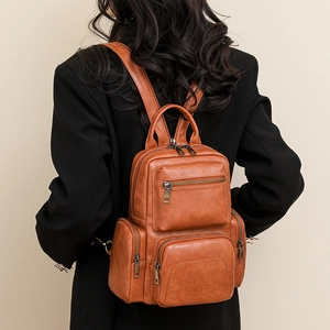 Brown vintage PU leather backpack with multi-zipper layers shown on a female model