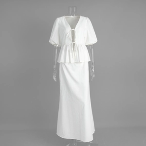 Detail of white cotton two-piece set featuring V-neck peplum top with puff sleeves