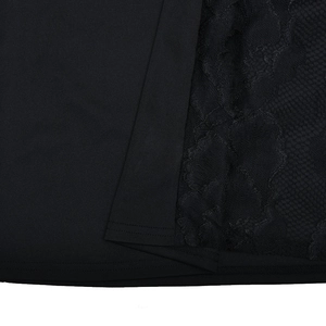 Détail du patchwork en dentelle noire et de la texture du tissu sur la robe moulante