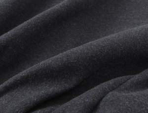 Macro shot of dark grey wool fabric texture showing detailed soft fibers on bomber jacket