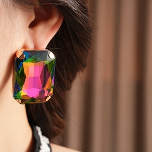 Detail of vintage rectangular gemstone earrings with colorful gradient and gold prongs