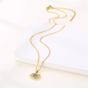 Golden Evil Eye necklace with zircon and turquoise pendant on white display board