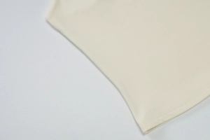Close-up of cream-colored knit texture and flat hem stitching on summer tank top