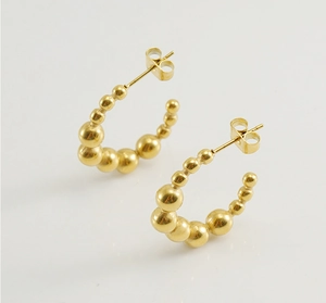 Detailed view of 18K gold plated C-shaped earrings with gradient beaded design and butterfly backs