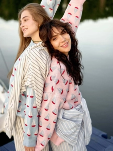 Gros plan sur la texture du pull en tricot avec motif jacquard de voilier rouge et blanc