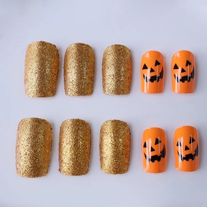 Unghie finte Halloween con glitter dorati e motivi di zucca arancione