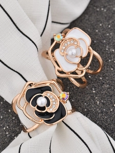 Detail of camellia scarf clip with pearls and rhinestones on striped fabric