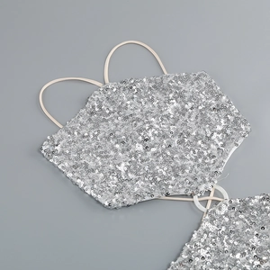 Macro view of silver sequins and metal ring detail on a slim evening dress strap