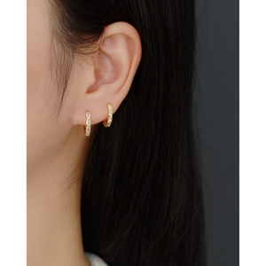 Close-up of gold S925 sterling silver hoop earrings with rectangular zircon on model