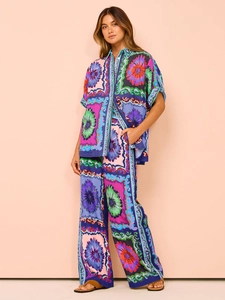Detail of vibrant floral print fabric on loose fit shirt and wide-leg trousers set