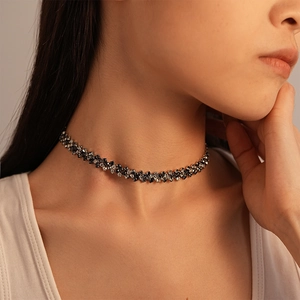 Macro detail of luxury geometric choker with black and white diamond pavé settings