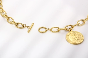 Close-up of gold coin pendant with religious relief and toggle clasp on chain