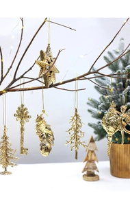 Detailed view of six golden Christmas ornaments hanging on branches with warm lights