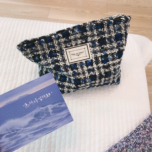 Blue and black tweed cosmetic bag with Time to Party label on quilted surface