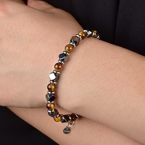 Gros plan d'un bracelet en perles d'oeil de tigre et acier inoxydable avec médaille gravée