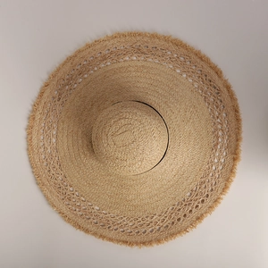 Detailed macro view of the raffia sun hat featuring frayed edges and hollow-out weave