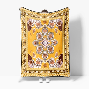 Yellow flannel blanket with decorative mandala patterns held by a model for size display