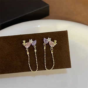Detailed close-up of vintage palace style drop earrings with pink zircon and gold chain