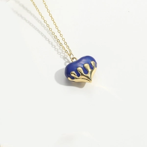 Macro shot of royal blue heart pendant with golden base and fine link chain