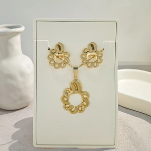Detailed view of woven texture round earrings and matching necklace set in golden finish