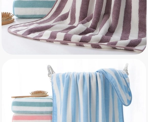 Detail of soft thickened coral fleece towels showing striped texture and absorbent fibers