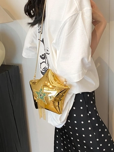 Macro shot of gold star-shaped bag with blue rhinestone inlay and long metal tassels