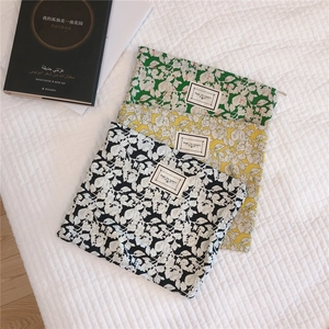 Flat lay of cotton floral pouches with leaf patterns and 'TIME TO PARTY' woven labels