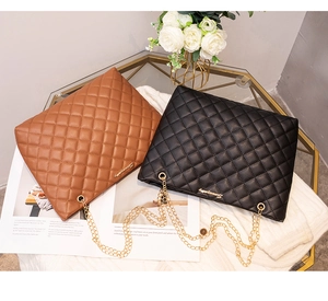 Sacs bandoulière matelassés marron et noir avec chaînes dorées sur une table élégante