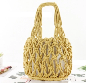 Detail view of yellow hand-woven straw tote bag with beige fabric lining and soft texture