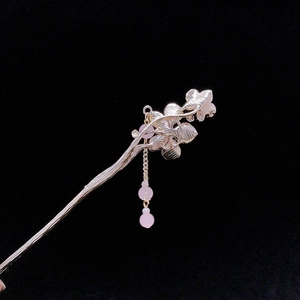Nahaufnahme einer goldenen Haarnadel mit rosa Perlenquasten im traditionellen China-Stil