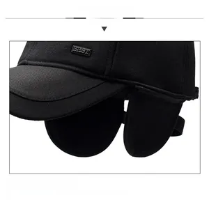 Dettaglio del cappello invernale nero con paraorecchie pieghevoli e targhetta in metallo